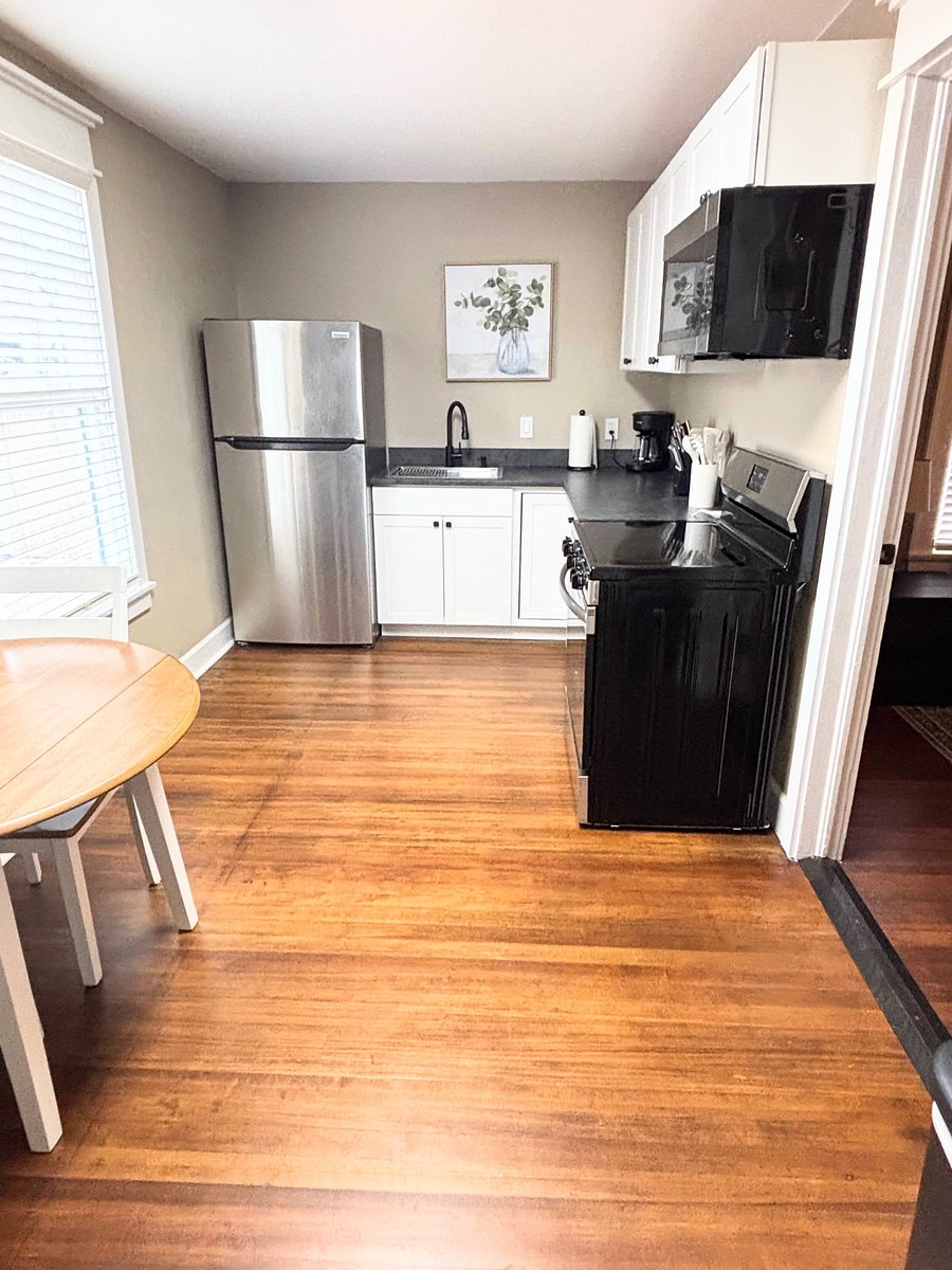 Kitchen with fridge, stove, microwave and small table
