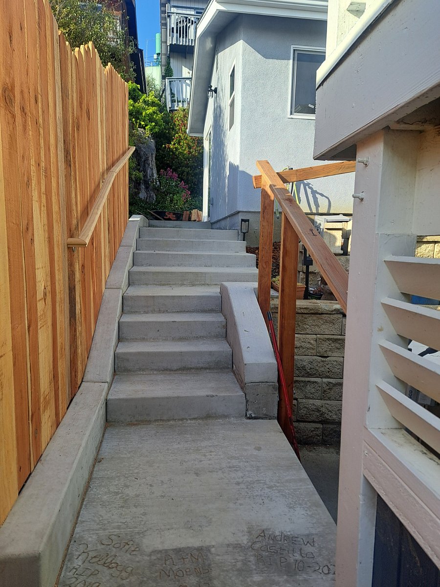 Fence between your home and neighbor's home for privacy and extra security. High end wide concrete staircase with safety hand rails.