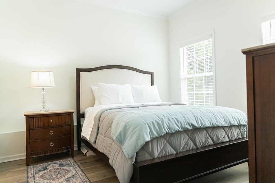 Bedroom with queen bed and mounted TV.