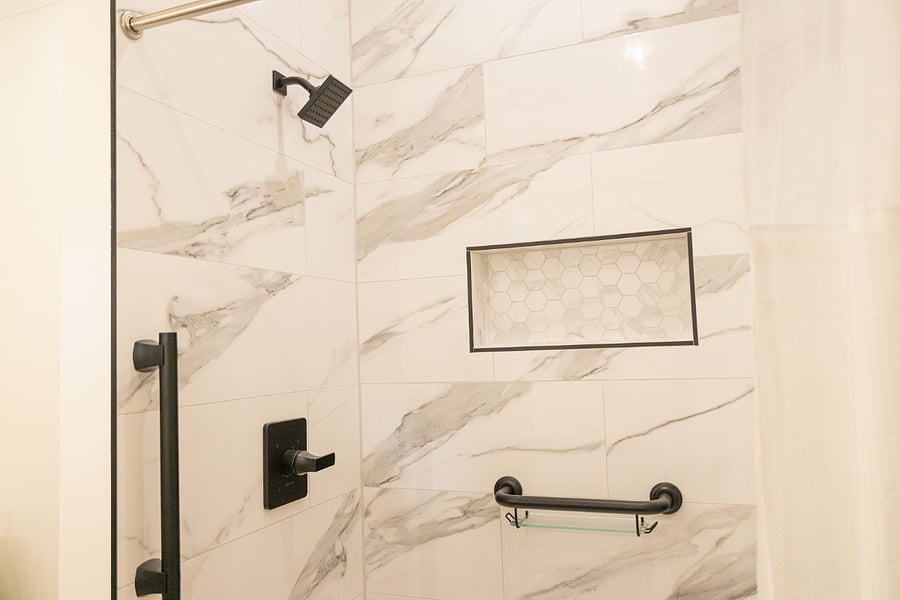 Walk in shower w/safety handlebars for seniors or to hold on to for shaving your legs.