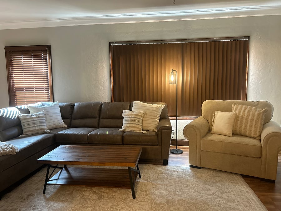 Freshly stained original woodwork with all new window blinds. View of the living room with large front window blinds shut. There are three large windows that open to the front of the unit giving you a street view.