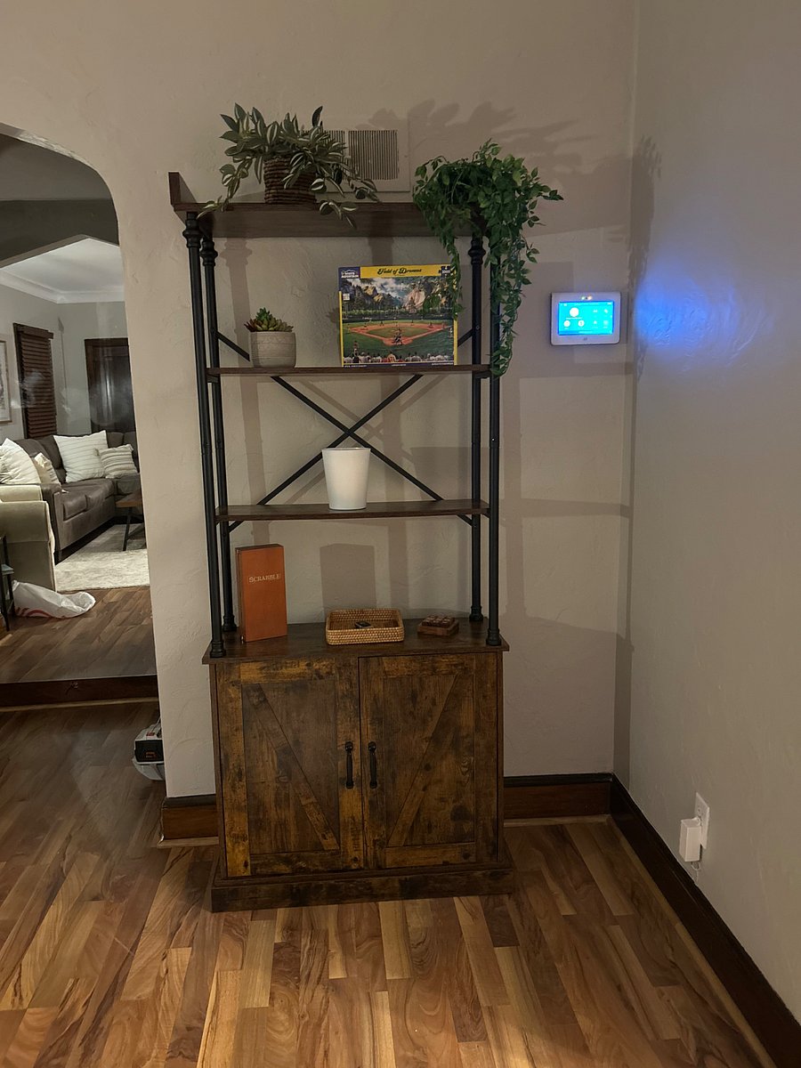 Bookshelf in living room + ADT Touchpad. Place your keys in the basket on cabinet top and store any of your books and games below! We started the game collection for you with Scrabble, Tic Tac Toe and a Field of Dreams Puzzle! 

The touchpad on the wall is your ADT system for additional security and peace of mind! 