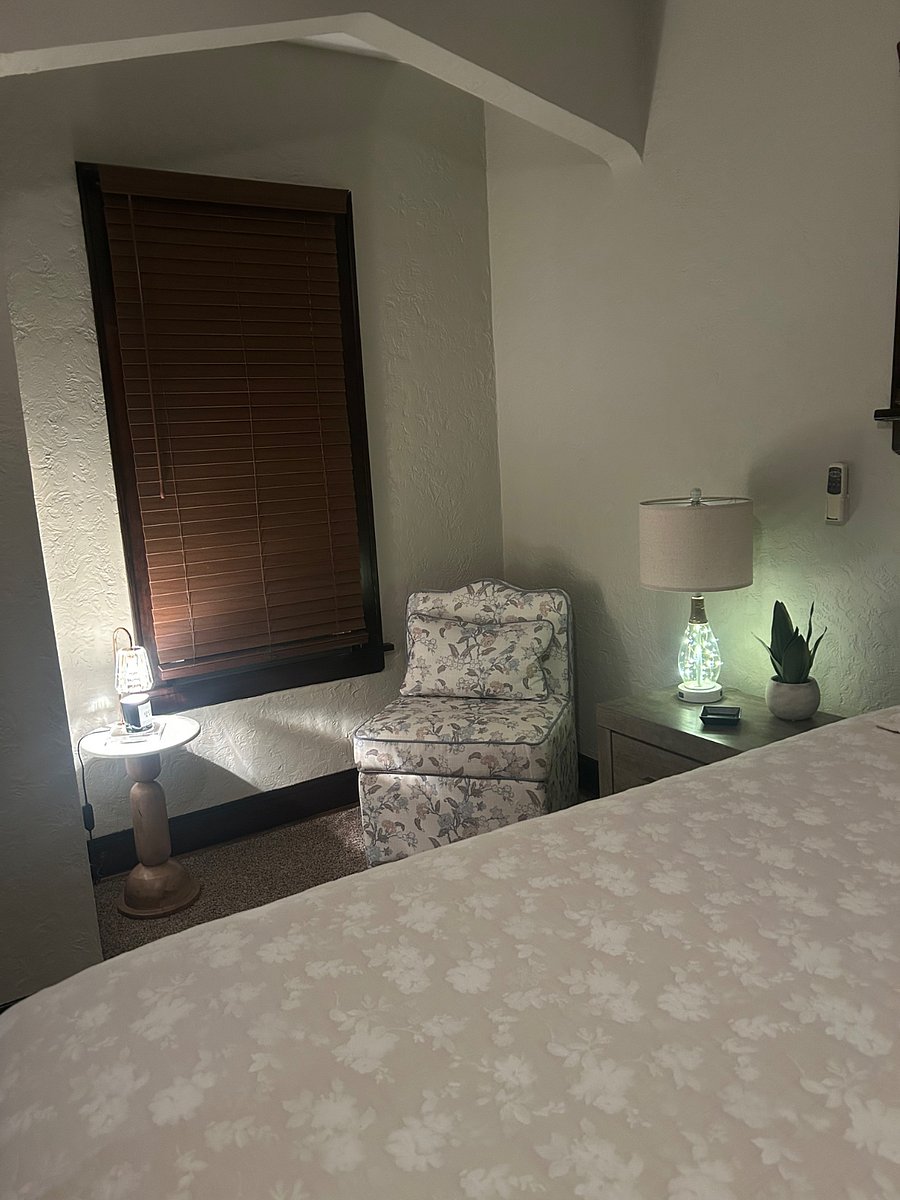 Sitting area next to the bed with an accent chair and a side table. 