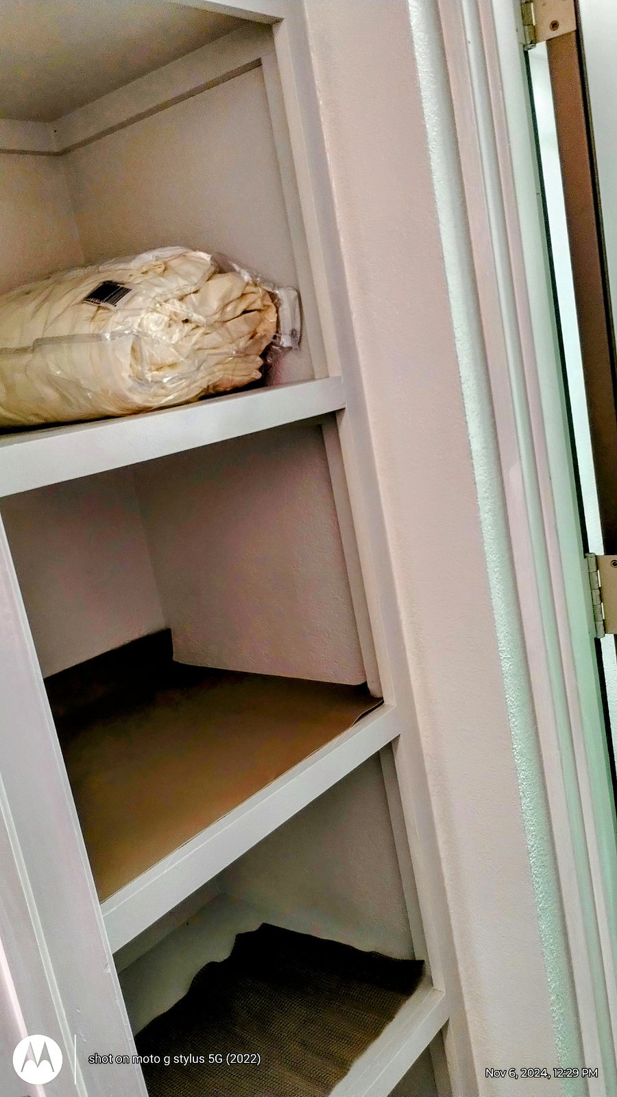 Built in shelving for extra storage, with extra linens and iron.