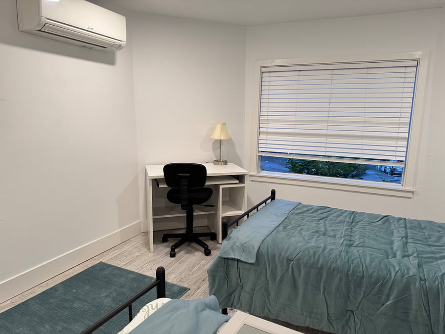 Front bedroom has two twin XL beds that combine into a single king-size bed. Room is also furnished with a desk and chair, armoire, bureau and nightstand.