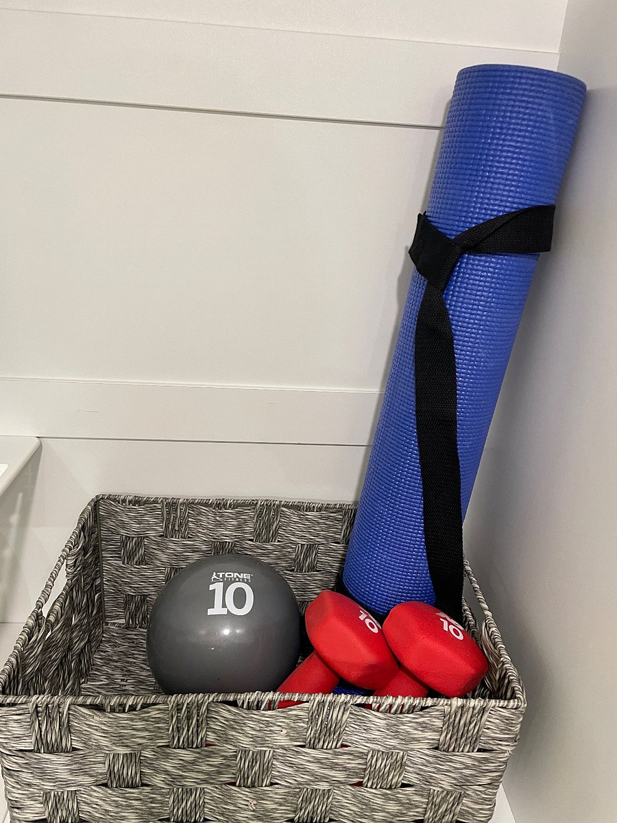 Exercise equipment includes yoga mat, free weights, and bicycle (bike stored in garage)