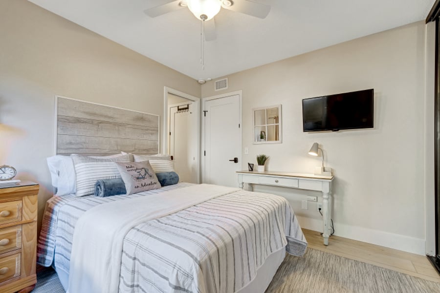 View of bedroom, desk space and TV.