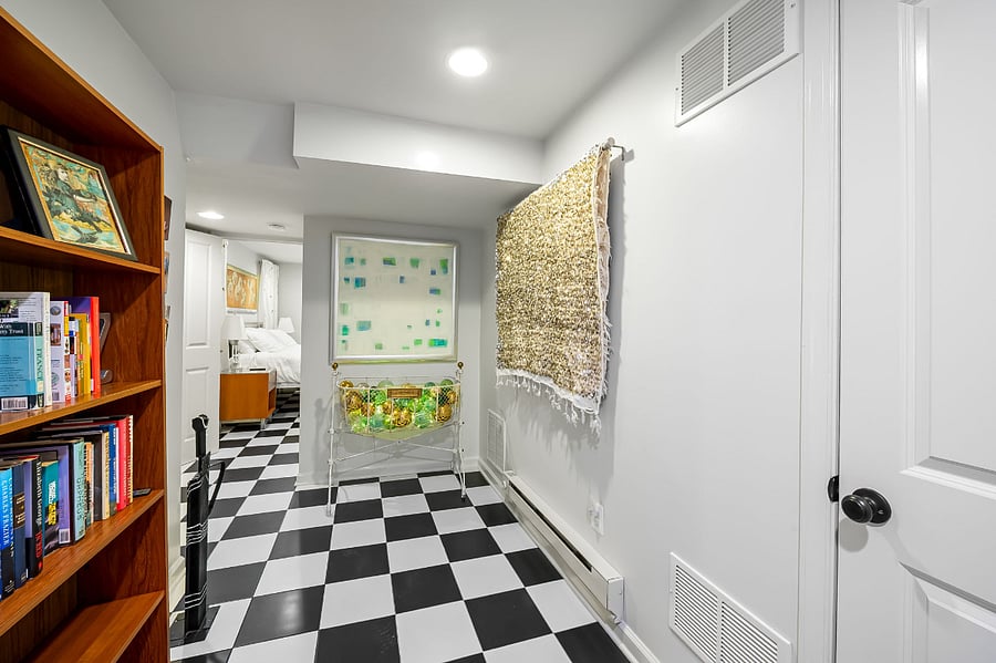 Hallway with original art and antiques, view into the back, quiet bedroom.