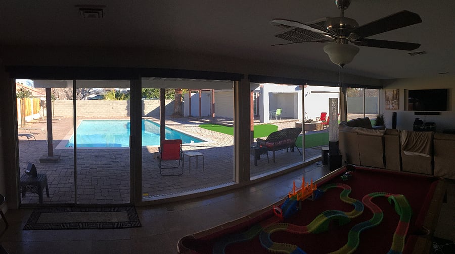 View from wall of windows in living space out to to the yard and large pool and casita.