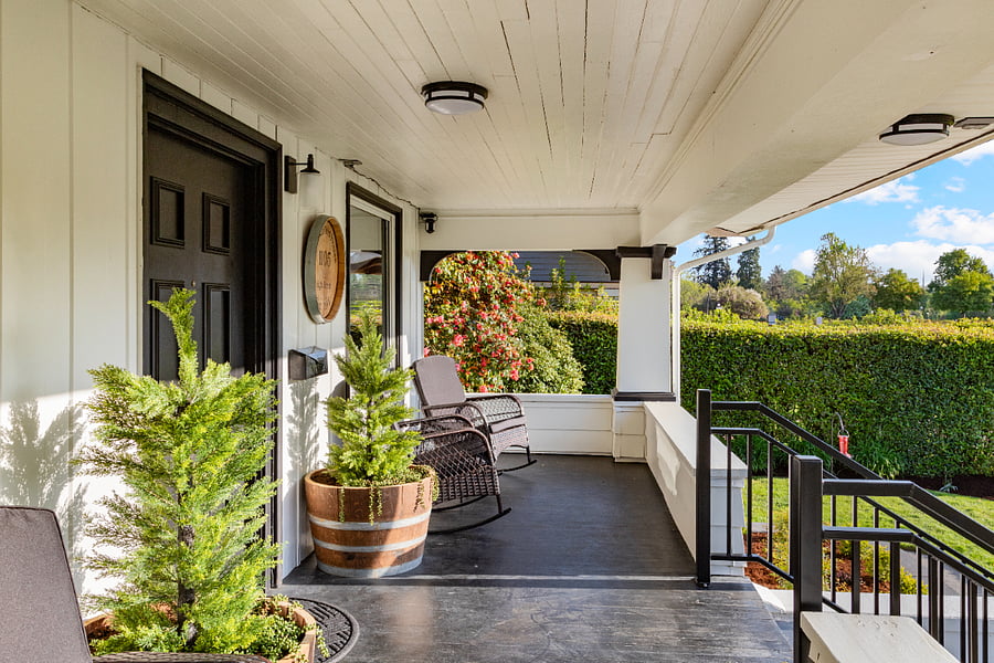 Guests are welcomed by a custom wine-themed sign that sets the tone for our home, complemented by trees in wine barrels, porch chairs, and scenic park viewscreating a charming, inviting atmosphere from the moment you arrive.