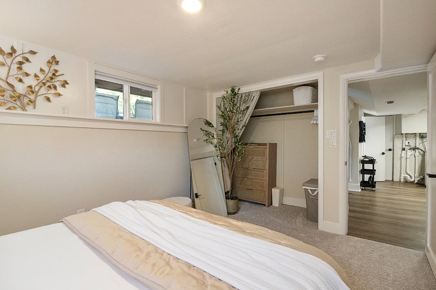 The Domaine Room closet has a large dresser, lots of room for hanging clothes, a hamper, trash can and tower fan.