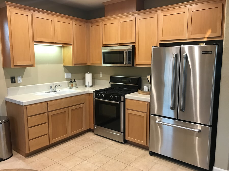 The kitchen is fully stocked with plates, utensils, cooking equipment, and high-end Bosch and Jenn Air appliances.