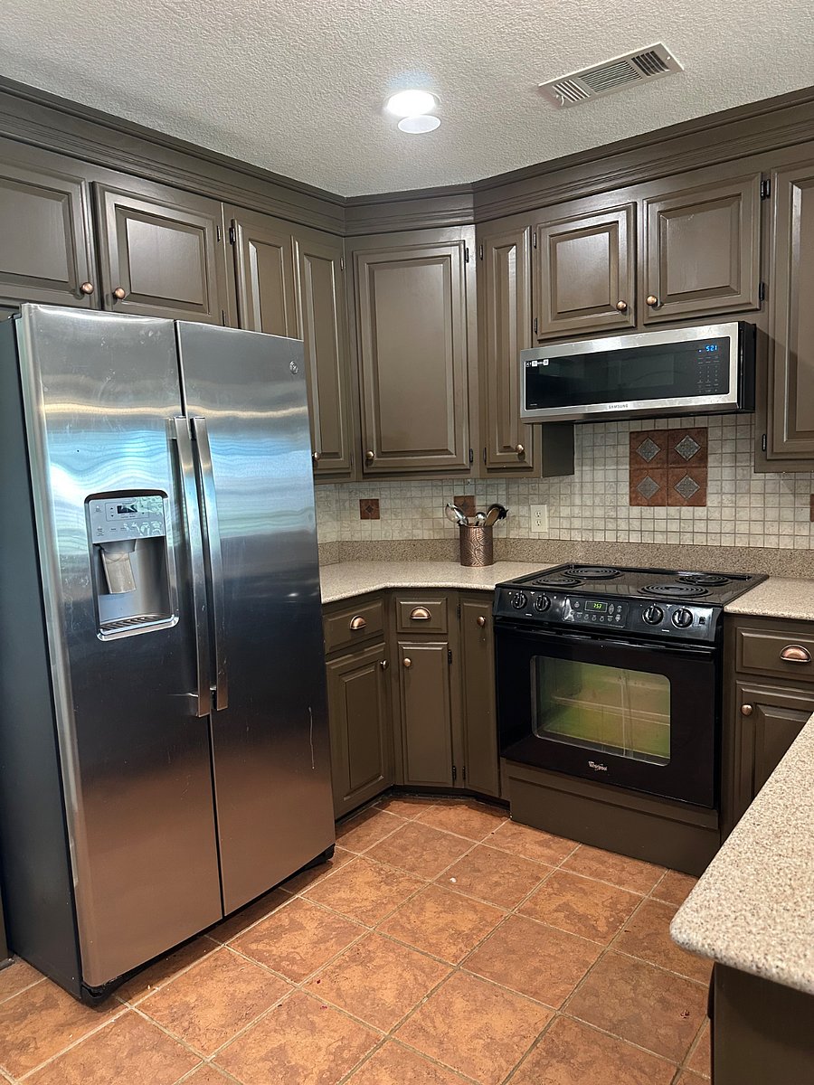 Microwave/vent hood above stove. Water and ice external dispenser in stainless steel refrigerator.