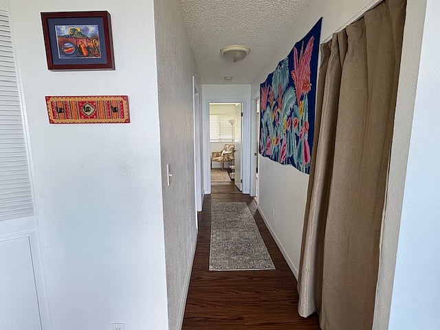 Hallway to bedrooms. Washer and dryer behind tan curtain