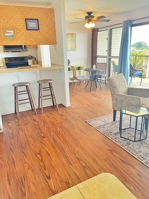 Galley kitchen with pass through to countertop with two bar height stools. As well as small dining table that can be used outside on the lanai.