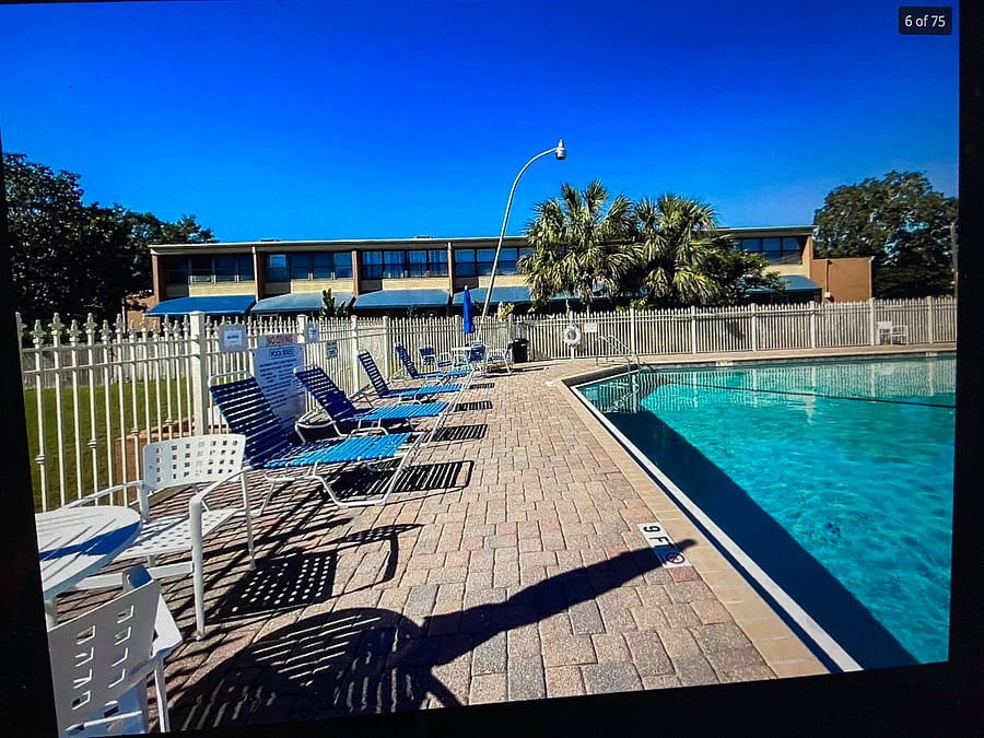 LOUNGING AREA AROUND SPACIOUS POOL.