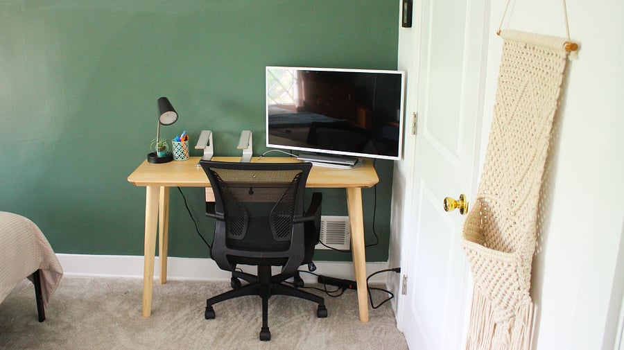 Your cozy workspace is set up with a dual monitor, docking station, laptop stand, and desk lamp. 