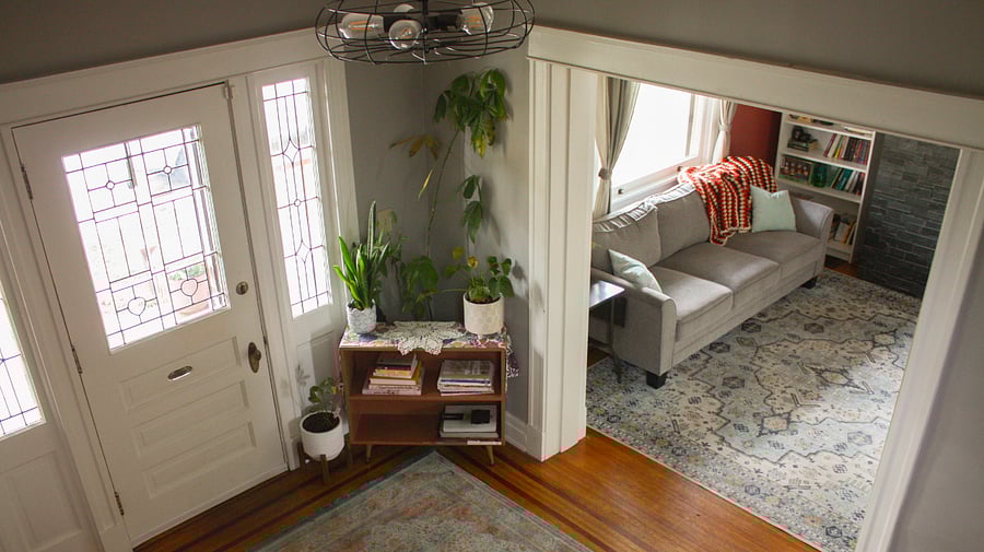 Standing on the stairs that lead up to the second floor, you can see the foyer and sitting room.