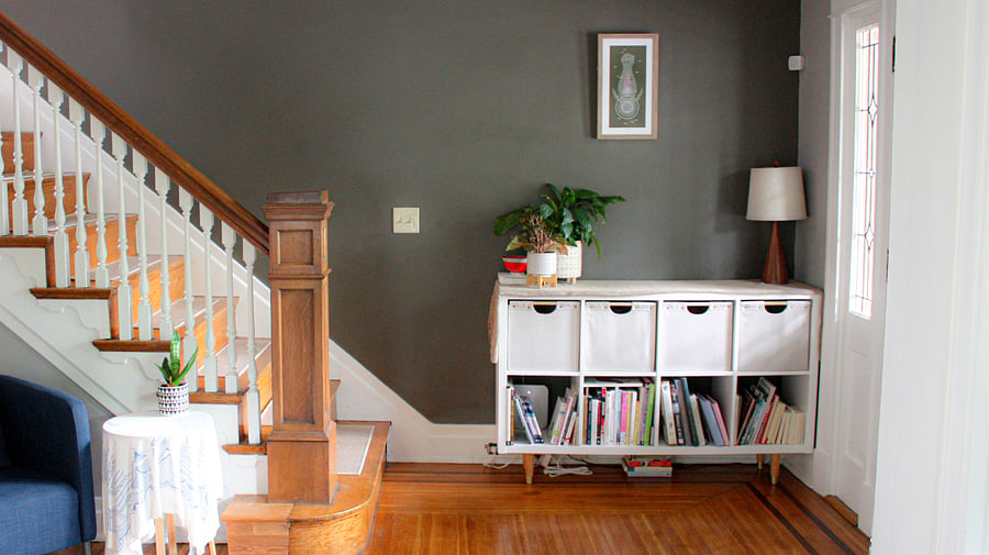 The grand foyer is warm and inviting with books, plants, and soft textures.