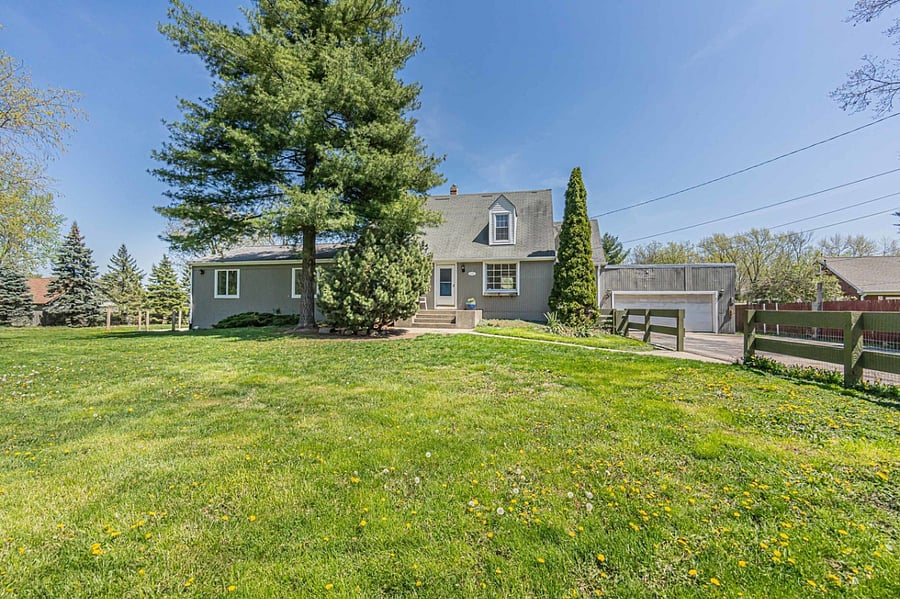 View of front of house. There are two more ranch gates. One by the garage going across to the neighbor's fence. The other along the pathway to the main house.