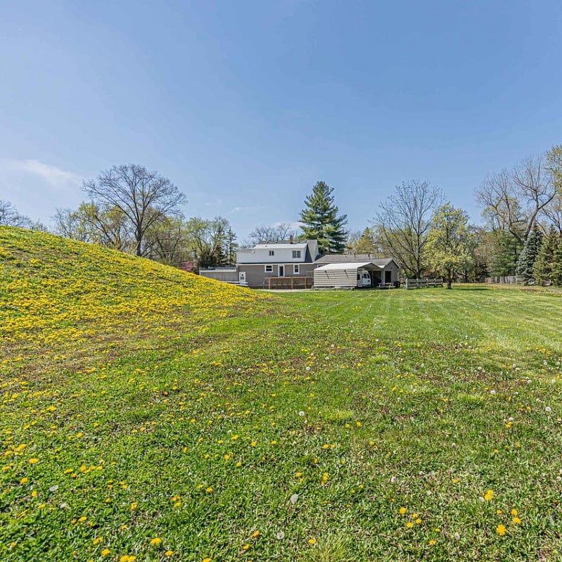 View from the back of property. 2.5 acres currently being excavated to level off and grade the land. There may be patches of unseeded earth as we clear out tree debris from the sides and the pond to beautify the property.