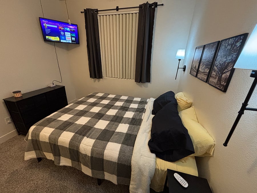 Bedroom 3 with queen bed, mounted smart tv, blackout curtains, noise machine, ceiling fan and remote control lights.
