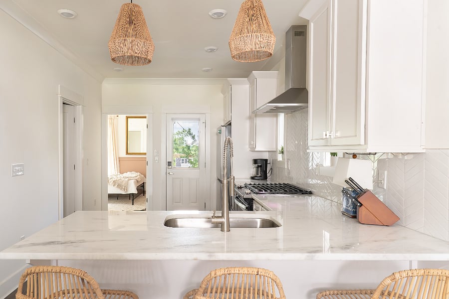Bar seating for three in the kitchen. The kitchen is next to the downstairs queen bedroom and bathroom. Easy access to the fenced backyard and 2-car parking pad with EV charger