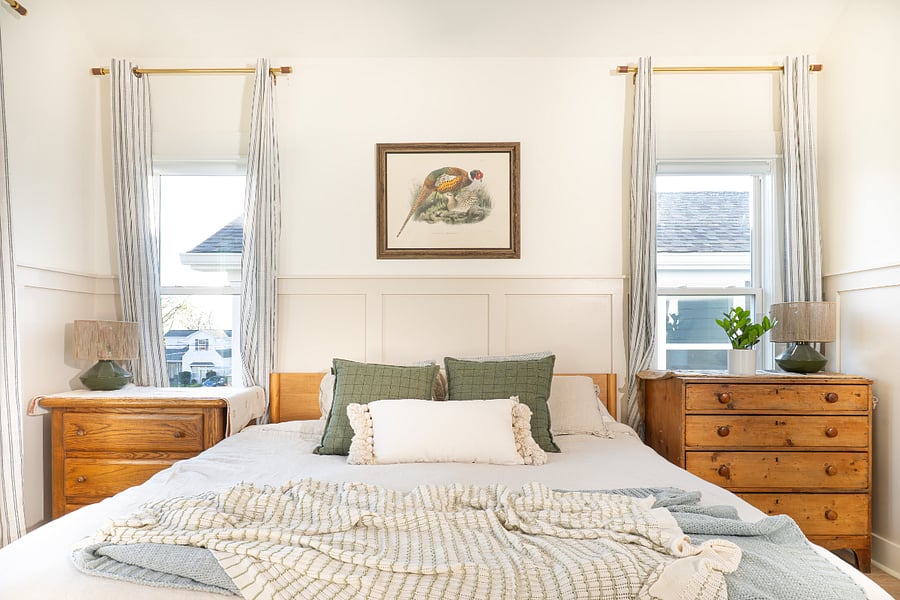 Primary bedroom featuring king bed, small balcony, smart TV, and writing desk. Flooded with natural light throughout the day