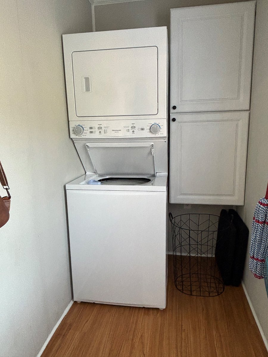 Brand new stackable large sized washer and dryer located in separate utility room by back door.