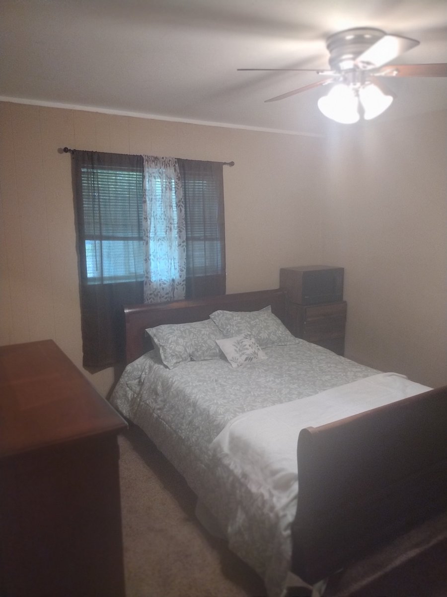 This is standard bedroom across from the master bedroom. It has Chester drawers with mirror, personal Tv, and a small microwave.