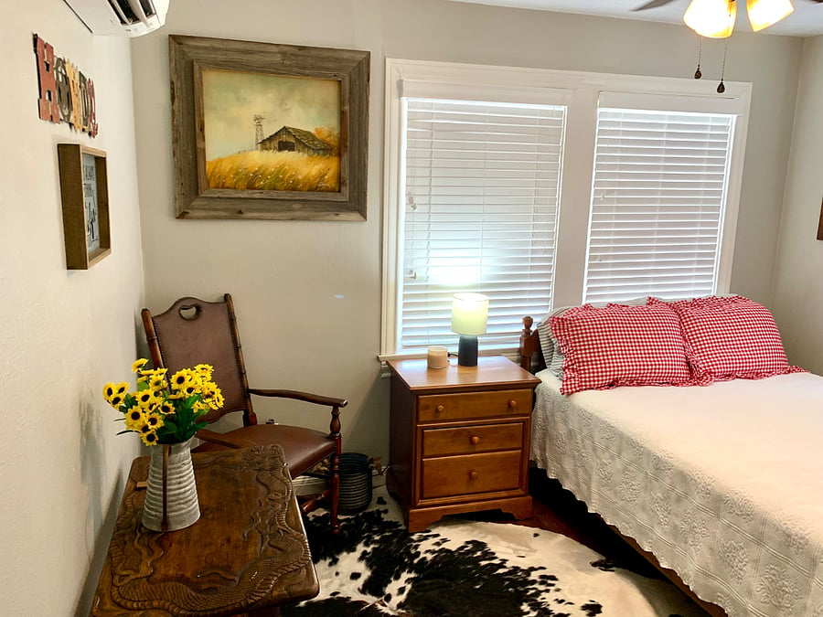 The Cowboy bedroom features a full-sized (double) bed with a new mattress, a cowskin run, an electric fireplace for ambiance, antique oil paintings, and a sixty-five year old deer bust that my dad shot on the King Ranch as a kid.