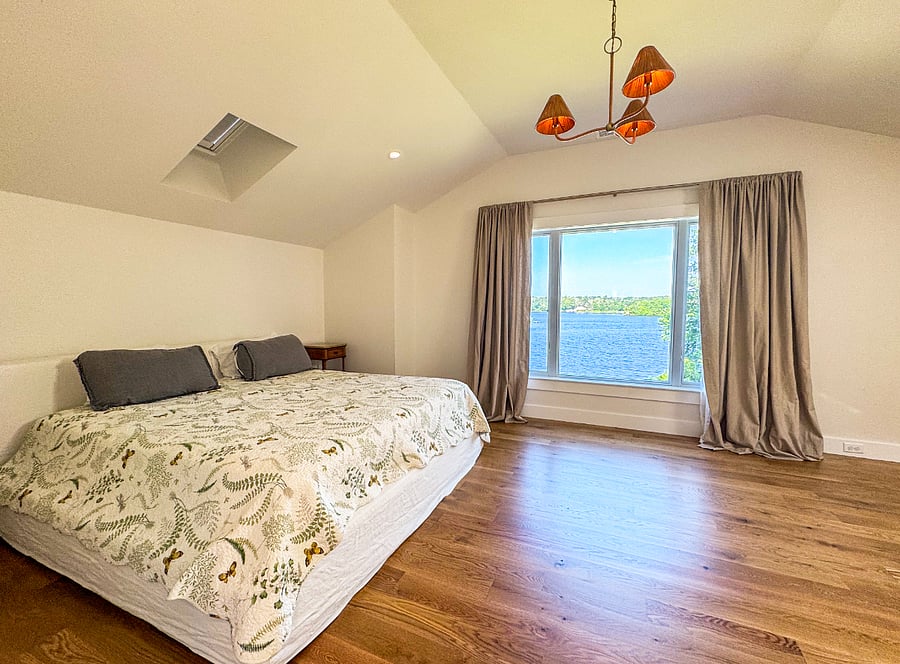 Master bedroom with king bed, skylight and lake view