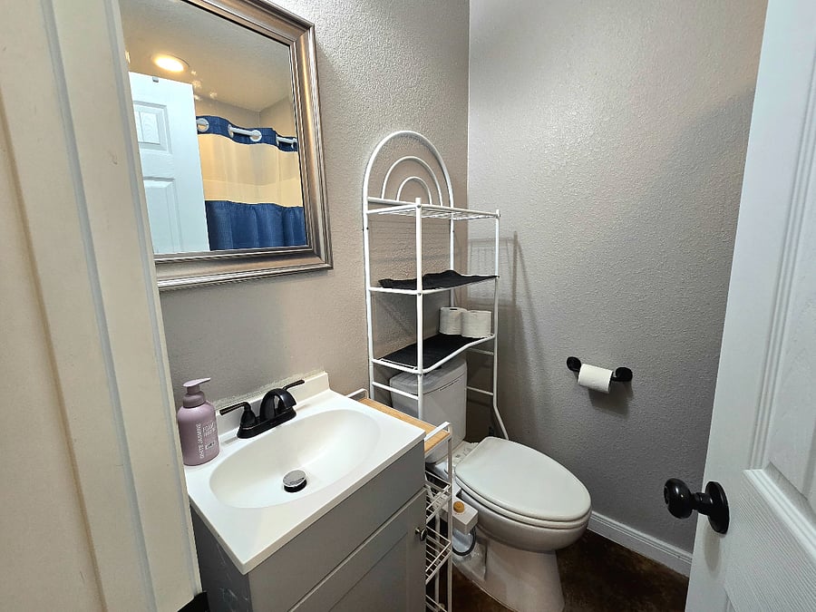 This bright bathroom is in the hallway. Refresh yourself with a shower or bath in the shower-tub combo.