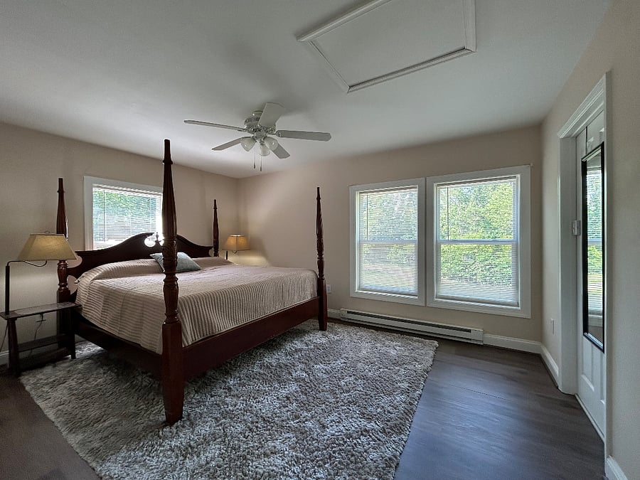 Bedroom with king-size bed and full length mirror on door leading to bathroom