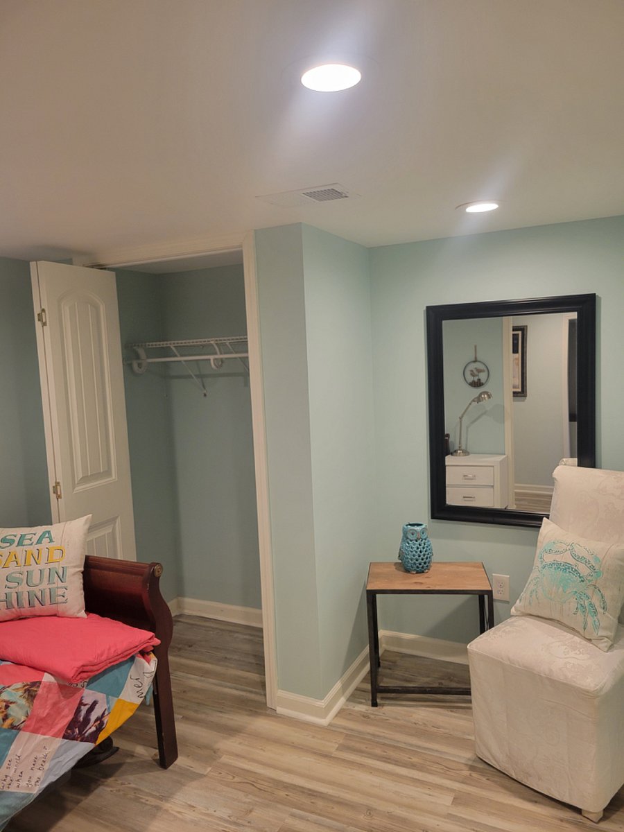 twin bed with with nightstand and chair (basement bedroom)