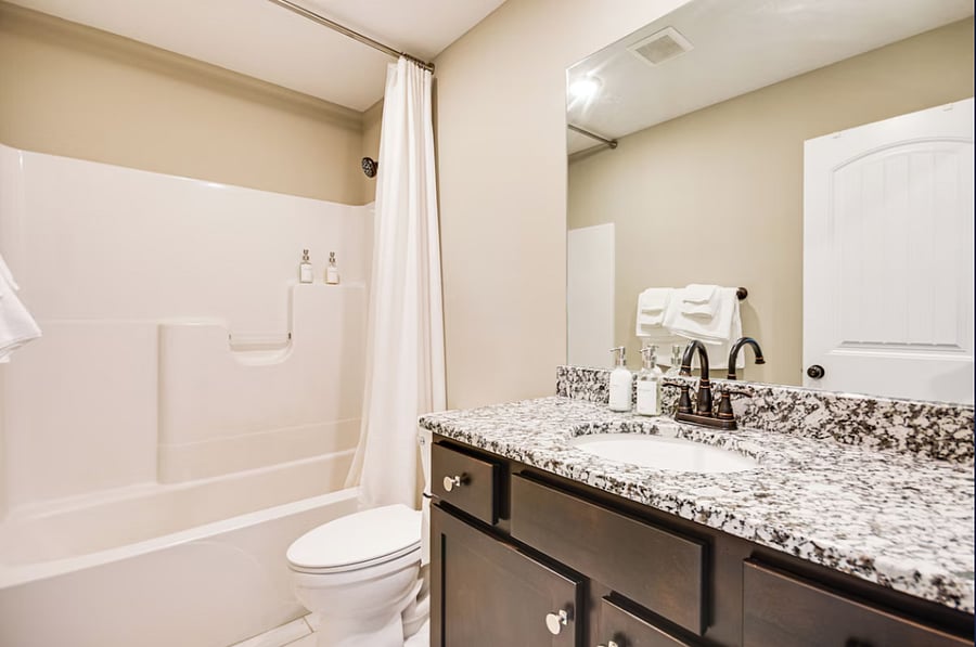 Hallway bathroom with bathtub and complimentary vegan toiletries.