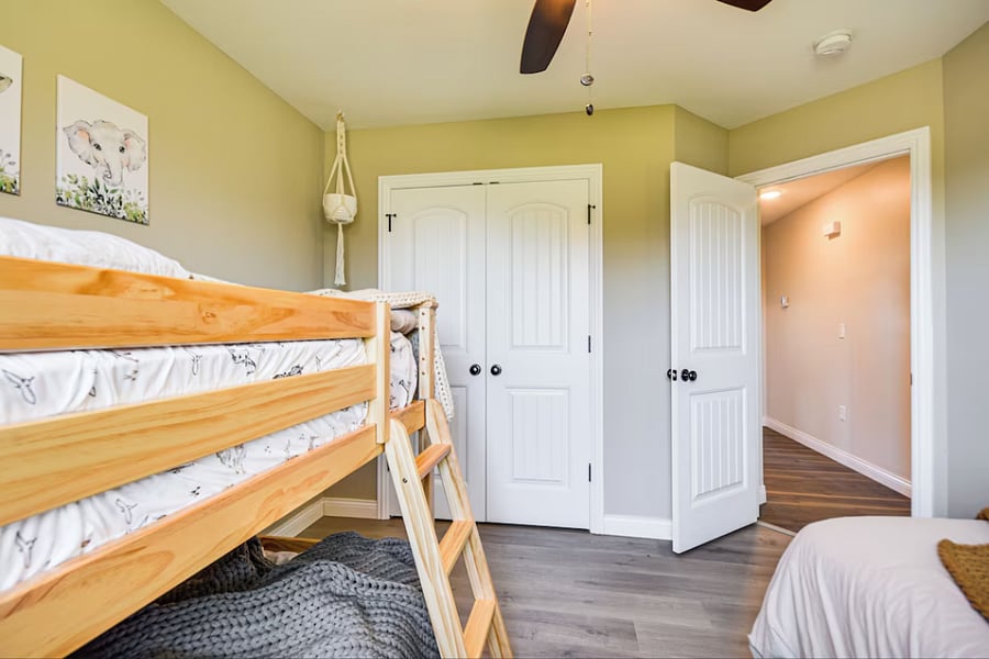 Twin bed plus bunk bed setup with open floor space for play and learning. Large closet for toys and clothes.
