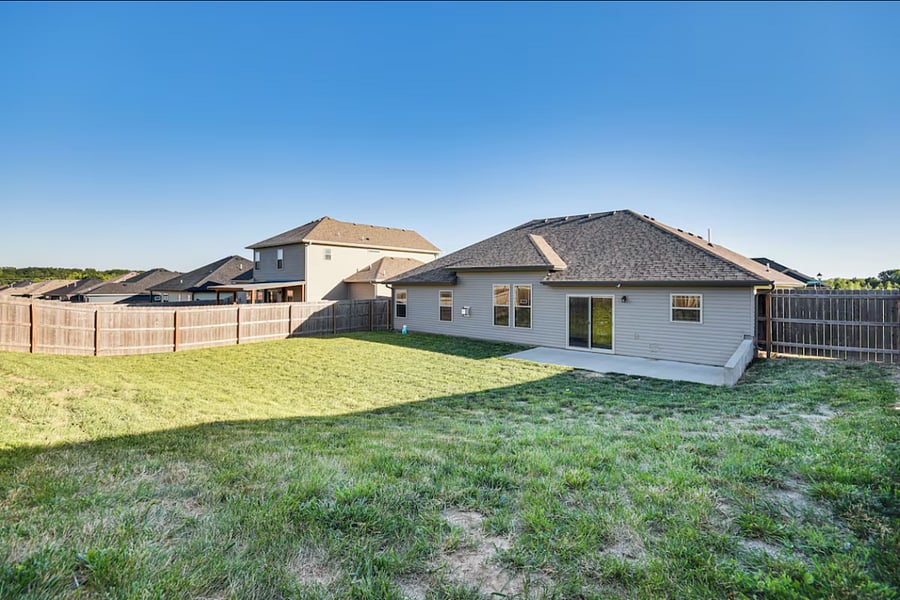 Fenced backyard with outdoor seatinggreat for relaxing while kids or pets enjoy the grass.