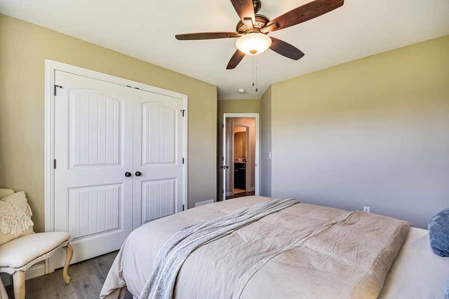 Tranquil room with queen bed, large wardrobe, accent chair, and blackout curtains for peaceful rest.