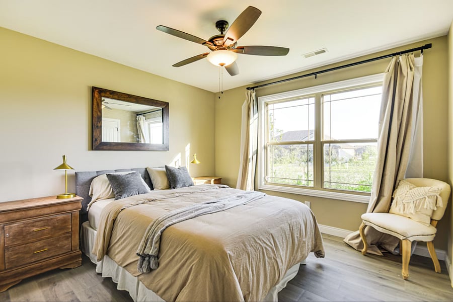 Tranquil room with queen bed, large wardrobe, accent chair, and blackout curtains for peaceful rest.