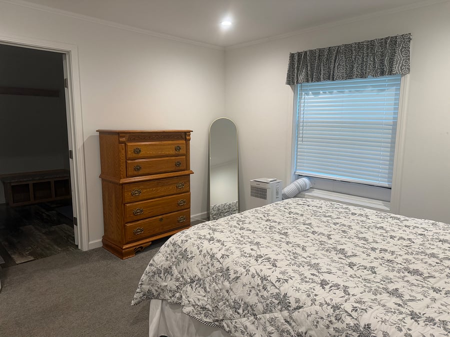 Master bedroom with queen bed, dresser, full length mirror, large walk-in closet, and master bathroom.