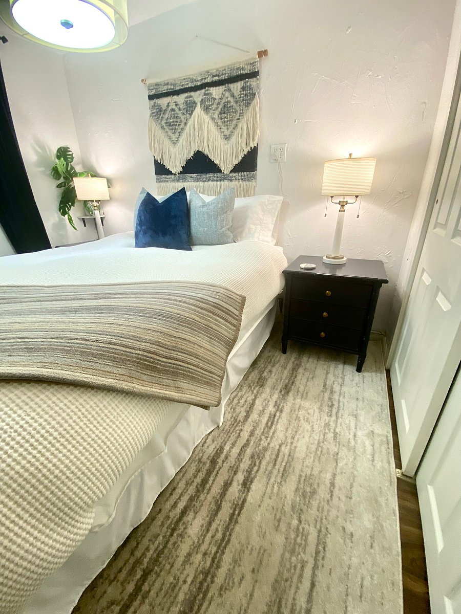Queen size bed in the bedroom off of the TV/fireplace area.