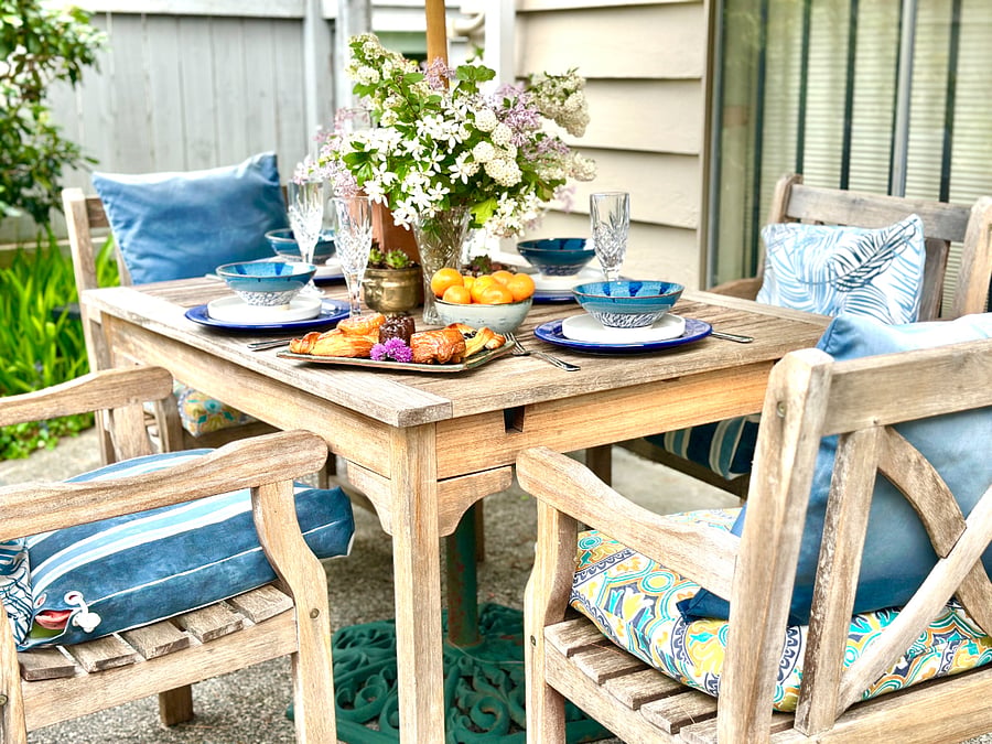 Umbrella covered Teak dining table and chairs for your outdoor dining enjoyment.