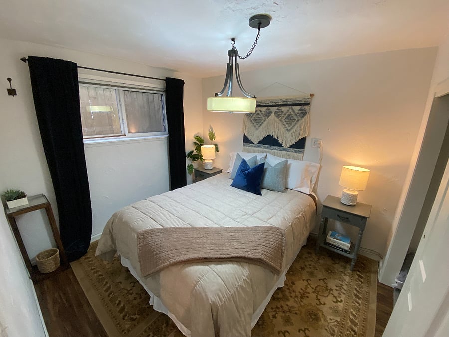 Queen size bed in the bedroom off of the TV/fireplace area.