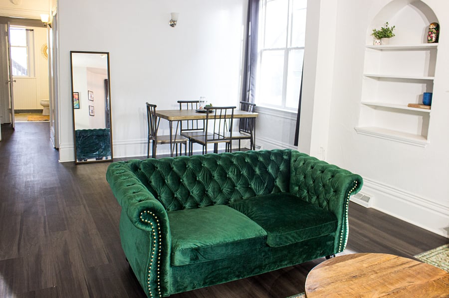 Table, chairs and sofa showing the hallway towards the bathroom and living room.