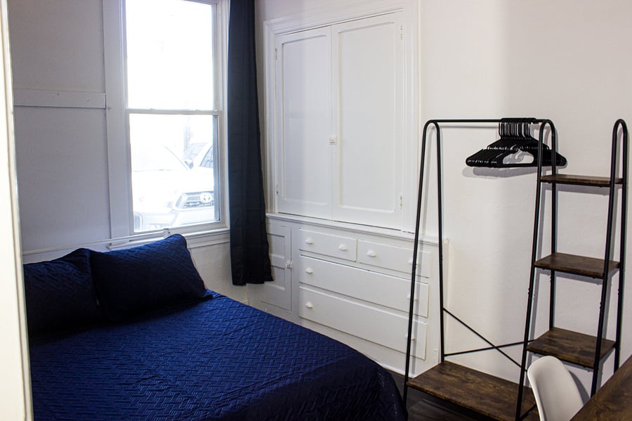 Spacious bedroom with a comfortable full bed, and blackout curtains.