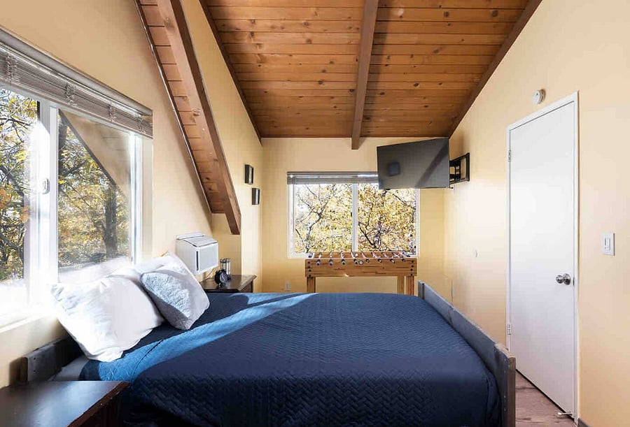 The upstairs guest bedroom is where the action is with a foosball table, TV - this room has 2 double beds with large windows to view the forest
