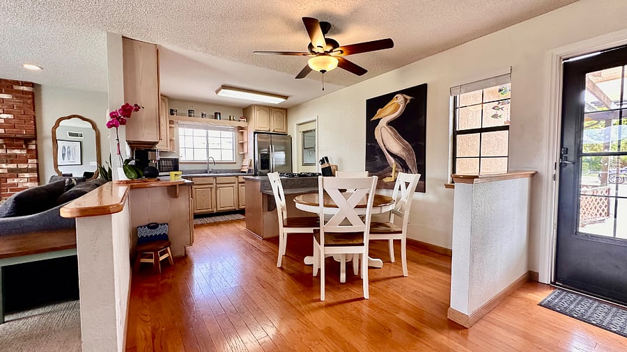 Dining table and small breakfast bar that opens into the living room with a half wall giving a great room feel.