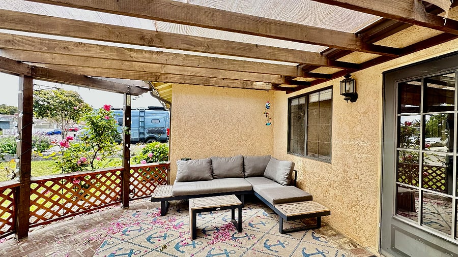 Cozy front porch with patio furniture and shade surrounded by stunning landscaping makes for the perfect place for coffee or an afternoon relaxation.