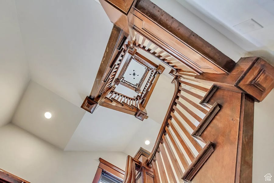 From below, the open well reveals the staircases sculptural geometryan elegant, multi-story stairway.